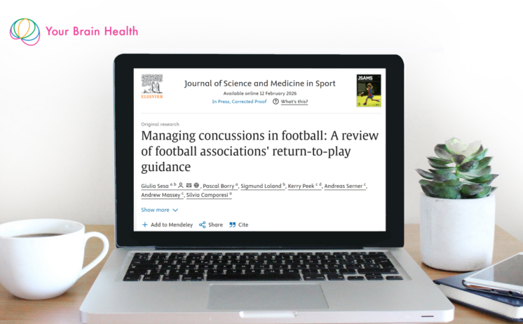 Your Brain Health Research in Focus May 2026 - laptop displaying a Journal of Science and Medicine in Sport paper on concussion return-to-play protocols across FIFA football associations